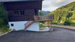 Un edificio con balcón de madera y camino de entrada pavimentado.
