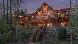 A large log cabin with multiple balconies and a staircase leading to the main entrance. - Rediker Retreat- Authentic Riverfront Luxury Log Home (Newry)