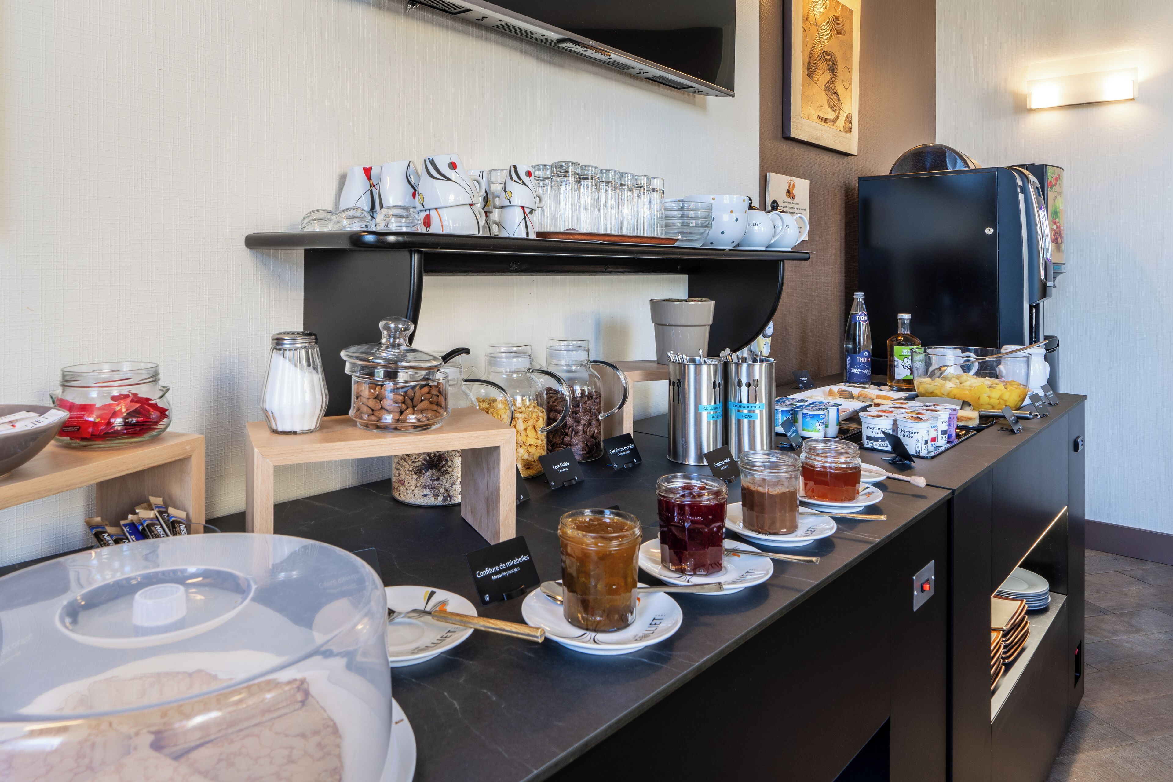 A buffet setup with various food items, condiments, and utensils.