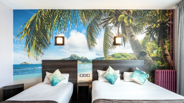 A hotel room with two beds, a mural of a beach and palm trees, and a view of the ocean. - Logis Hotel des Ducs (Alencon)
