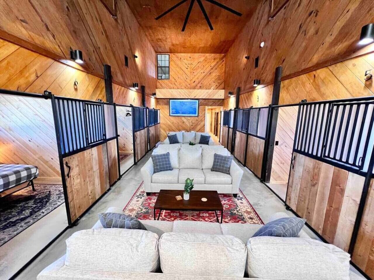 A spacious living area with a sofa set, a coffee table, and a TV mounted on the wall.