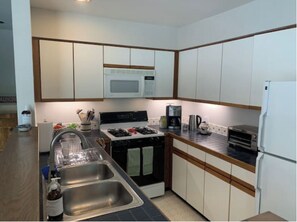 Enjoy cooking in this well-equipped kitchen with a black stove, microwave, coffee maker, and toaster.