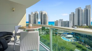 Un balcón con vista a edificios altos y a un área de piscina.