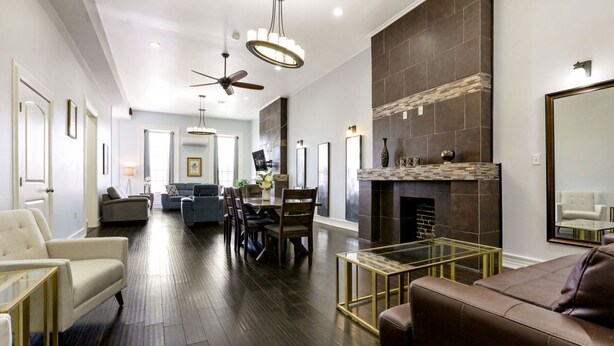 Una sala de estar amplia con chimenea, comedor y zona de estar con sofás y sillones.