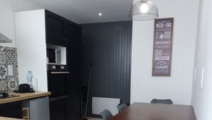 Una cocina moderna con comedor, que incluye una mesa y sillas de madera, un dispensador de agua y un microondas.