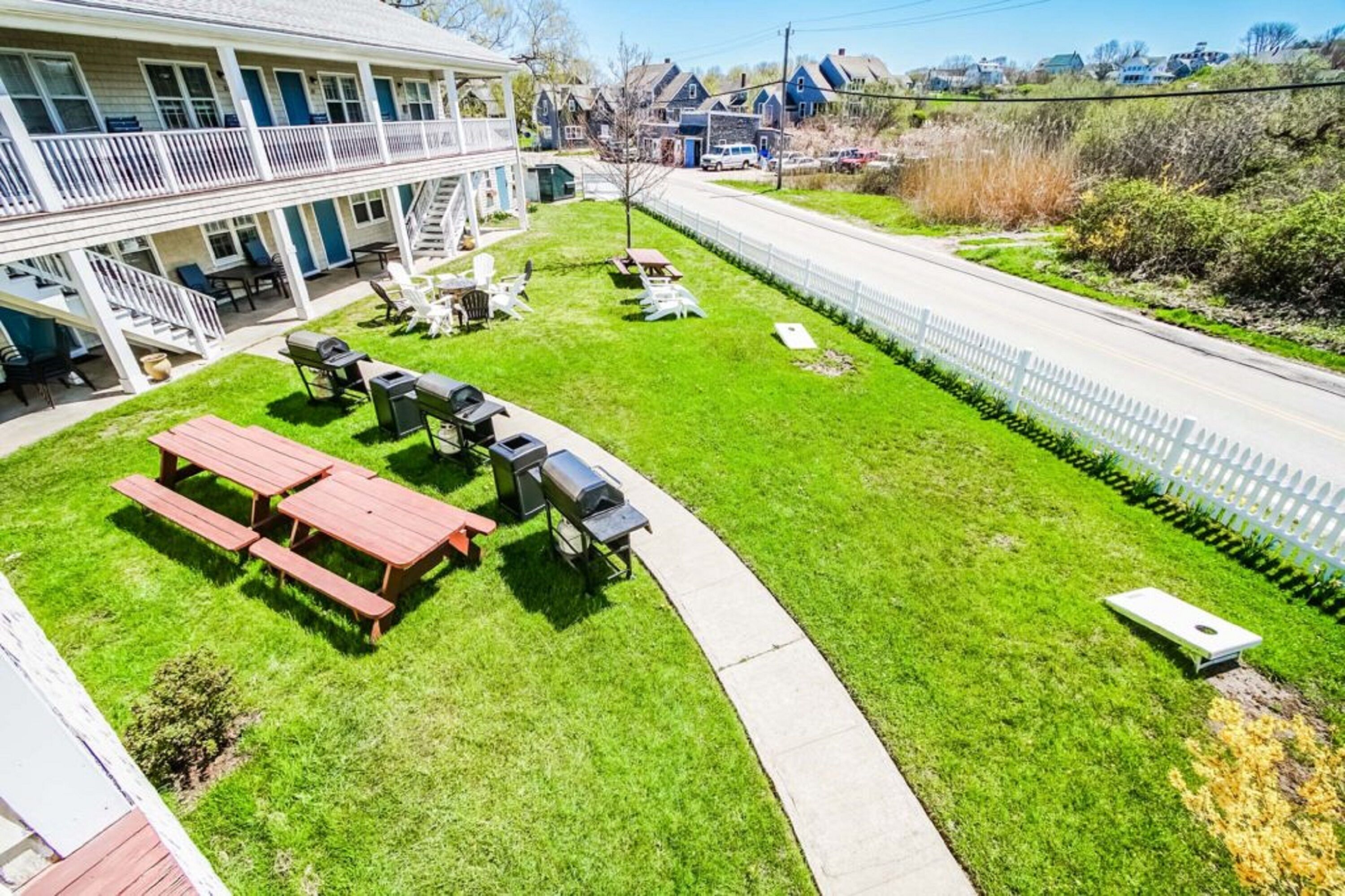 A two-story building with a patio area featuring picnic tables and grills.