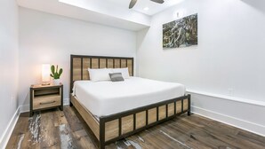 Un dormitorio con cama, mesita de noche y ventilador de techo.