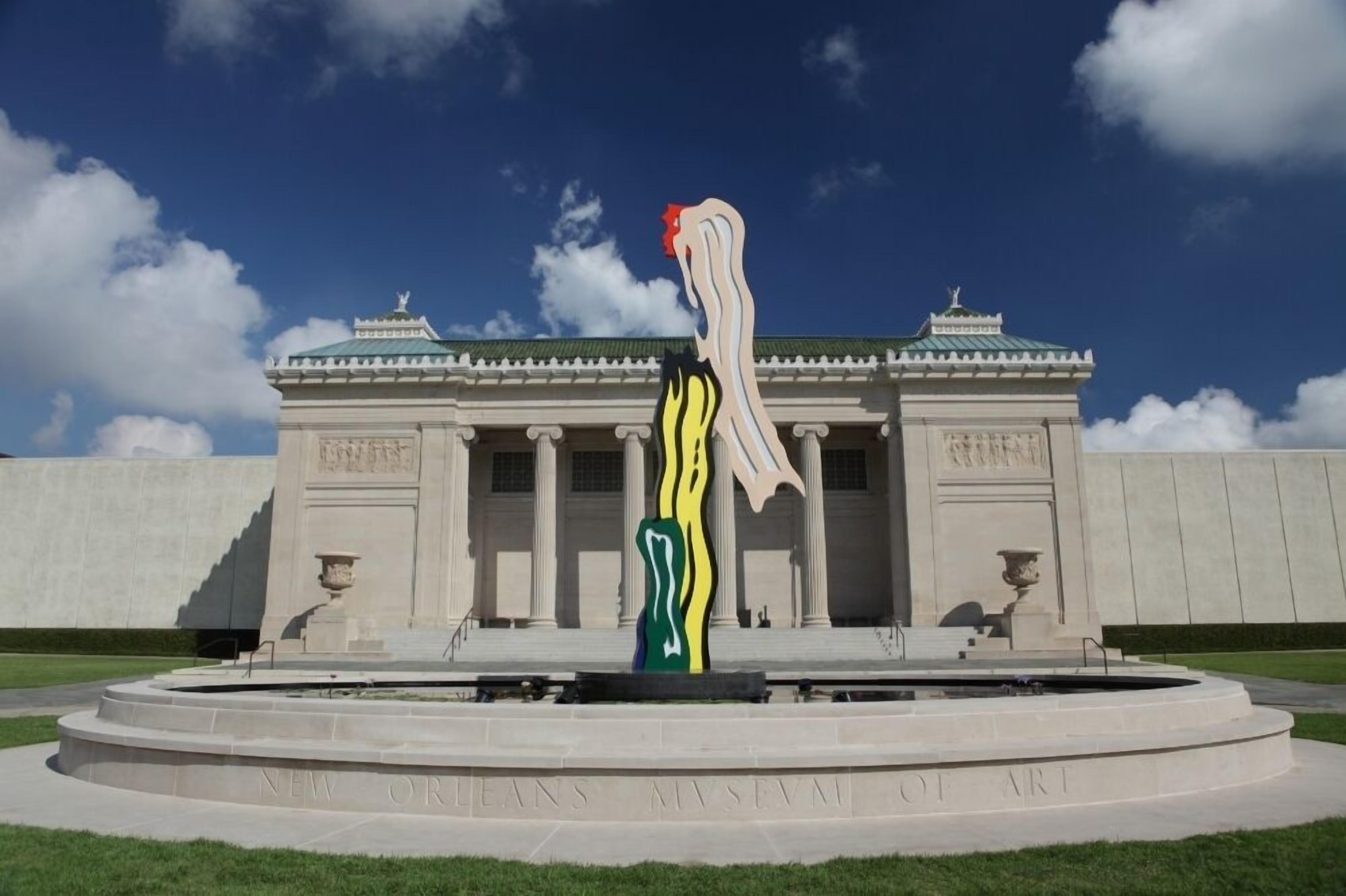 Un musée à l’architecture classique, avec une sculpture moderne en premier plan.