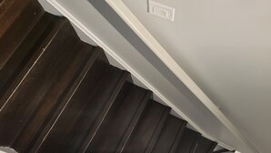 Eine Treppe mit dunklen Holzdielen und weißen Wänden.