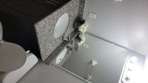 Ein Badezimmer mit Toilette, Waschbecken und Spiegel.
