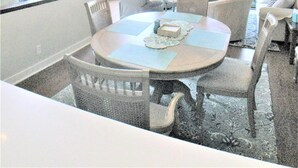 Ein Essbereich mit einem runden Tisch, Stühlen und einer Deckenleuchte. Über dem Tisch befindet sich ein Deckenventilator.