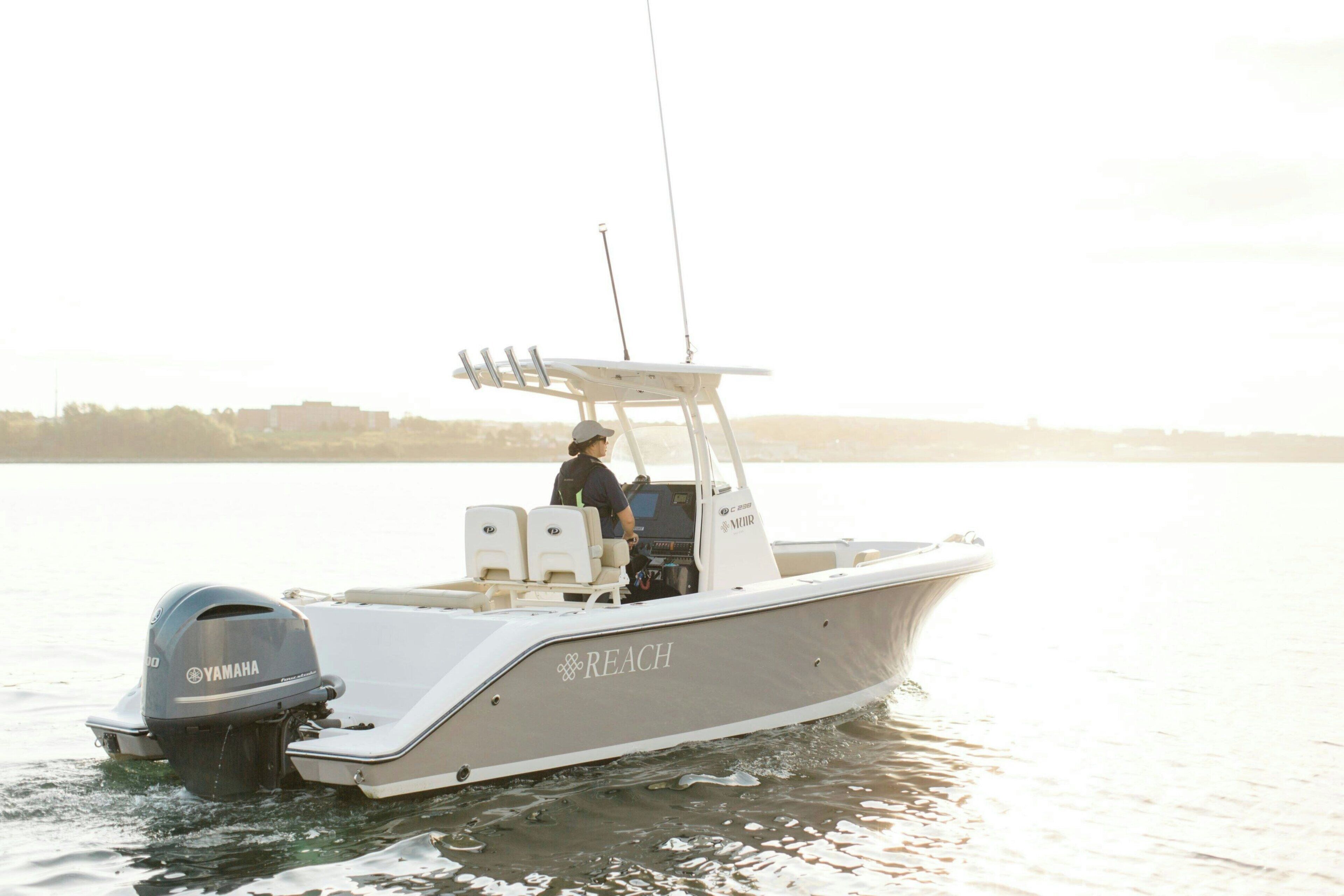 A motorboat with a Yamaha outboard motor, a white cabin, and the word "REACH" on the side.