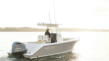A motorboat with a Yamaha outboard motor, a white cabin, and the word "REACH" on the side.