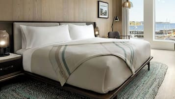 A hotel room with a large bed, a view of the sea, and a wooden wall.
