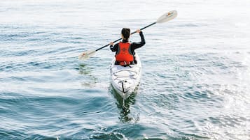 Una persona haciendo kayak sobre aguas tranquilas.