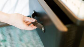 Une main tenant une clé près d’une poignée de porte.