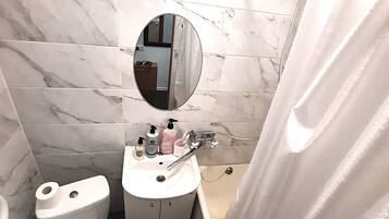 Een bad, een haardroger, pantoffels, handdoeken