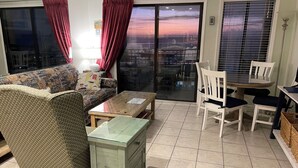 Una sala de estar con sofá, mesa de centro y un comedor con sillas y una mesa.