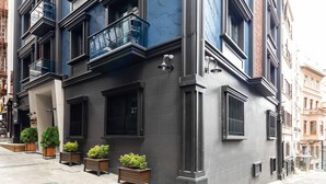 Ein mehrstöckiges Gebäude mit moderner Fassade, großen Fenstern und einem Balkon mit Metallgeländer.
