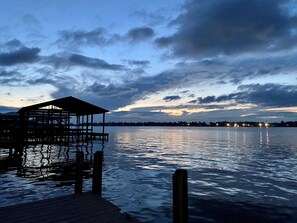 A wooden pier extending into calm water with a covered structure at the end.