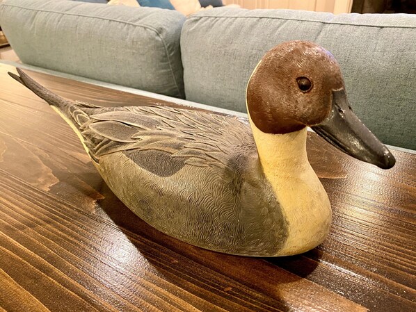 A wooden table with a duck sculpture.