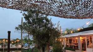 Ein Außenbereich mit Holzterrasse, Sitzgelegenheiten und einer Pergola.