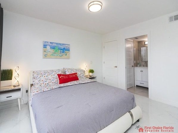 A modern bedroom with a bed, a nightstand, a wall-mounted lamp, and a painting.