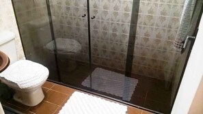 Chuveiro, toalhas de banho, sabonete, papel higiênico