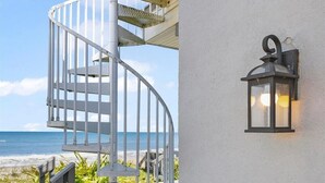 Eine Wendeltreppe führt zu einem Balkon mit Blick auf das Meer.