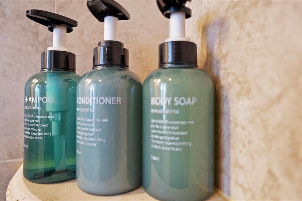 Three bottles of shampoo, conditioner, and body soap with pumps.