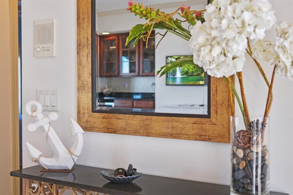 A kitchen with wooden cabinets, a black countertop, and a decorative anchor.