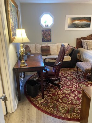 A cozy living room with a wooden table, a leather chair, a patterned rug, a sofa, and a painting on the wall. - Secluded 3 bed 2 bath condo close to Memorial Park, Five-points, & UGA in Athens (Athens)