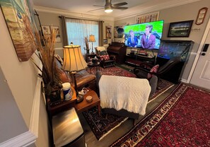 A living room with a television, leather sofa, and a patterned rug. - Secluded 3 bed 2 bath condo close to Memorial Park, Five-points, & UGA in Athens (Athens)