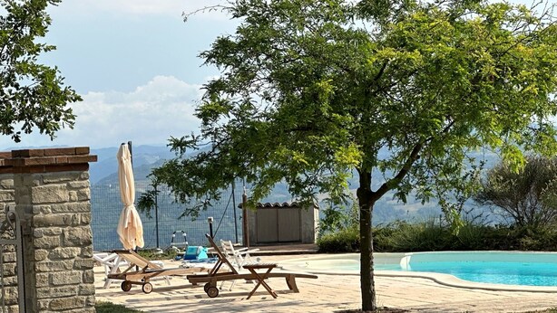A pool area with lounge chairs, a stone wall, and a view of mountains. - Casa San Rocco Piemonte - bjergtop - 360 udsigt - pool. (Montabone)