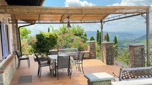 A covered patio with outdoor furniture, stone walls, and a view of the landscape. - Casa San Rocco Piemonte - bjergtop - 360 udsigt - pool. (Montabone)