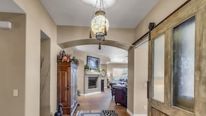 A hallway with a wooden cabinet, a patterned rug, and a decorative ceiling light. - Oasis in the desert - your hiking and biking paradise. (Scottsdale)