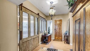 A hallway with wooden doors, a chandelier, and a patterned rug. - Oasis in the desert - your hiking and biking paradise. (Scottsdale)