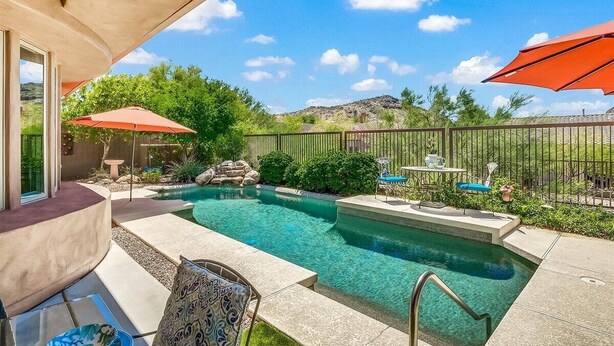 A backyard with a swimming pool, patio furniture, and a fenced area. - Oasis in the desert - your hiking and biking paradise. (Scottsdale)