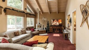 A cozy living room with a fireplace, sofas, a coffee table, and a television. - Big Bear Biltmore. Walk to the Park and Lake. Spa. (Big Bear Lake)