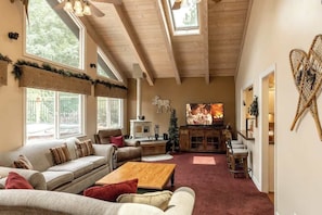 A cozy living room with a fireplace, sofas, a coffee table, and a television.