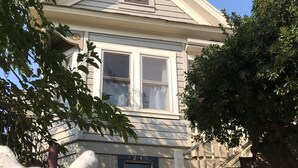 A house with a front porch, a mailbox, and a number '124' on the door. - Historic Hoffman House (Auburn)