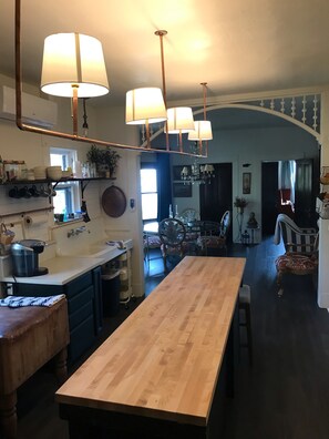 A spacious kitchen with a central island, pendant lighting, and a view into the dining area.