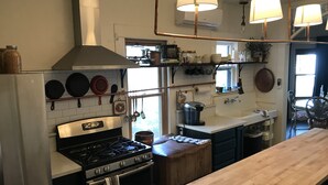 A kitchen with a stove, oven, and a wooden table. - Historic Hoffman House (Auburn)