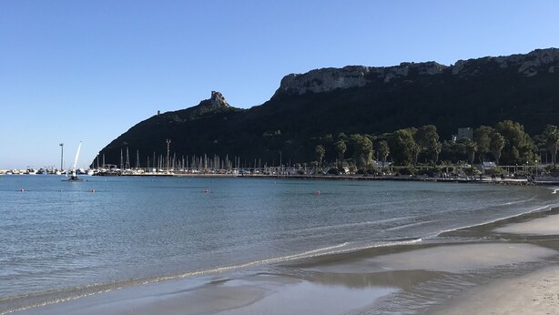 A beach with a clear sky, calm water, and a distant sailboat. - Country house (Pula)