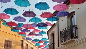 A street with buildings on either side and colorful umbrellas hanging overhead. - Country house (Pula)