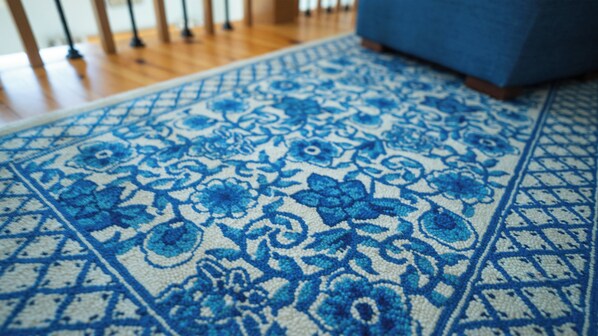Un gros plan d’un tapis bleu et blanc à motifs, orné de motifs floraux.