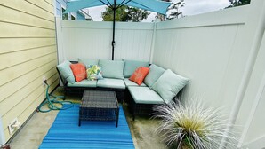 A backyard with a light blue patio set, a blue rug, and a white fence. - Cute beach house, 2 min walk to the beach (Myrtle Beach)