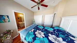 A bedroom with a bed, a ceiling fan, a door, and a wall-mounted mirror. - Cute beach house, 2 min walk to the beach (Myrtle Beach)