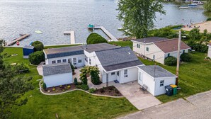 A residential area with houses, a dock, and a lake. - Lakefront Cottage with kayaks, paddleboat, aqua mat, & BIG deck close to Elkhart (Saint Cloud)