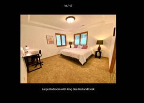 Un dormitorio amplio con una cama tamaño king y un escritorio.